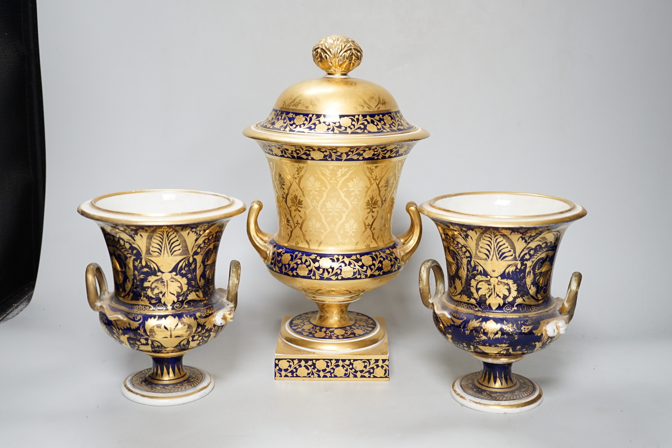A pair of Derby flower basket painted urns, c.1810, and a larger Derby urn and cover, first quarter 19th century, latter 30cm